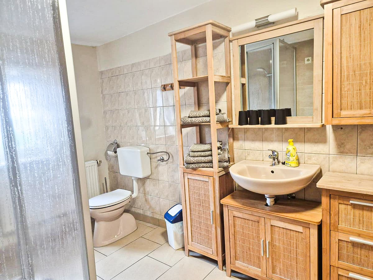 Bad der großen Ferienwohnung mit Dusche und Waschtisch