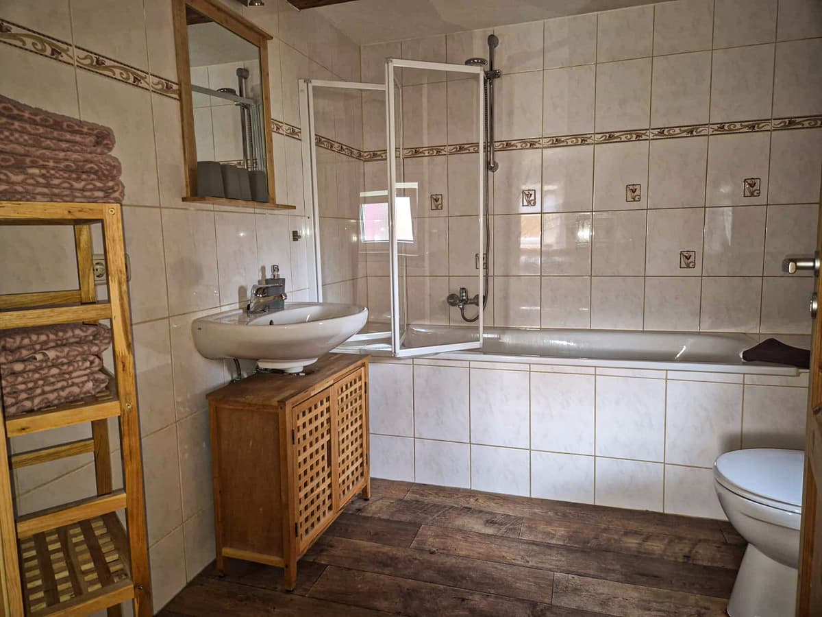 Bad der kleinen Ferienwohnung mit Badewanne, Dusche und Waschtisch